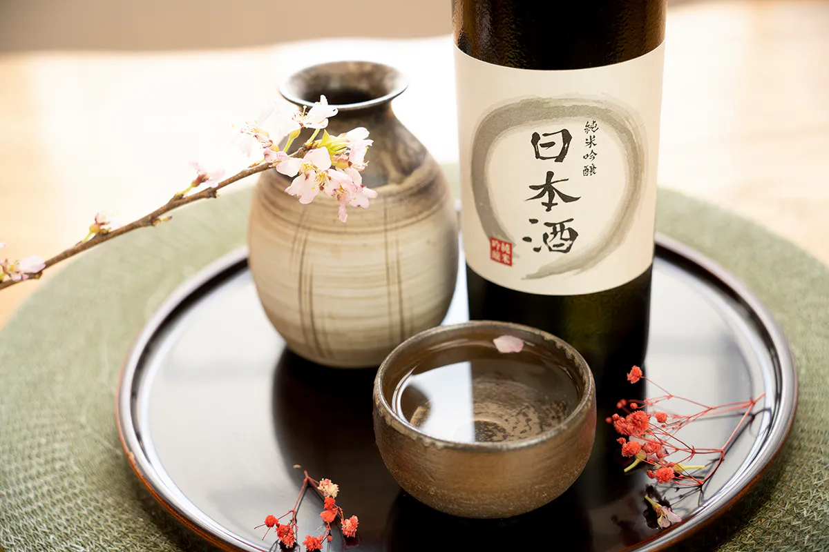 Japanese sake bottle and cup arranged with cherry blossoms